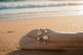 Pearl earrings on a textured beige surface with a shell in the foreground
