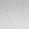 Fern green colored silk thread necklace with single floating white pearl on greay background by xomango 