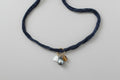 Tahitian pearl, mother of pearl Pikake flower, and amber bead hang from a denim blue silk ribbon necklace by xomango