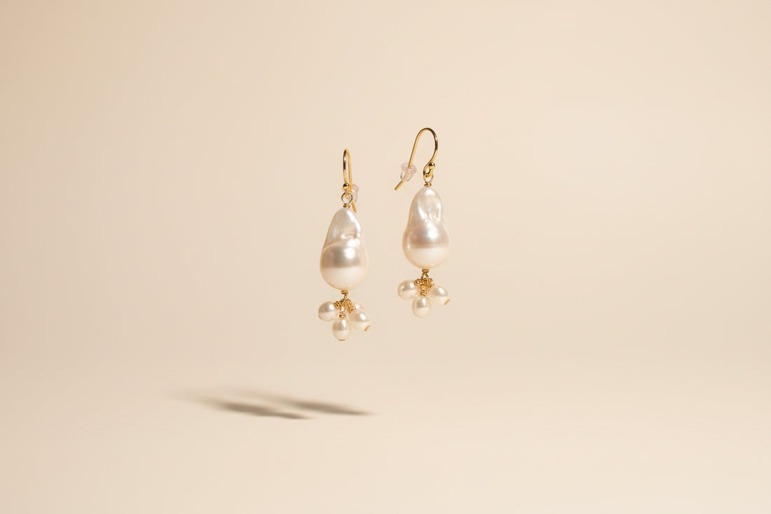 Pearl earrings on a textured stone surface