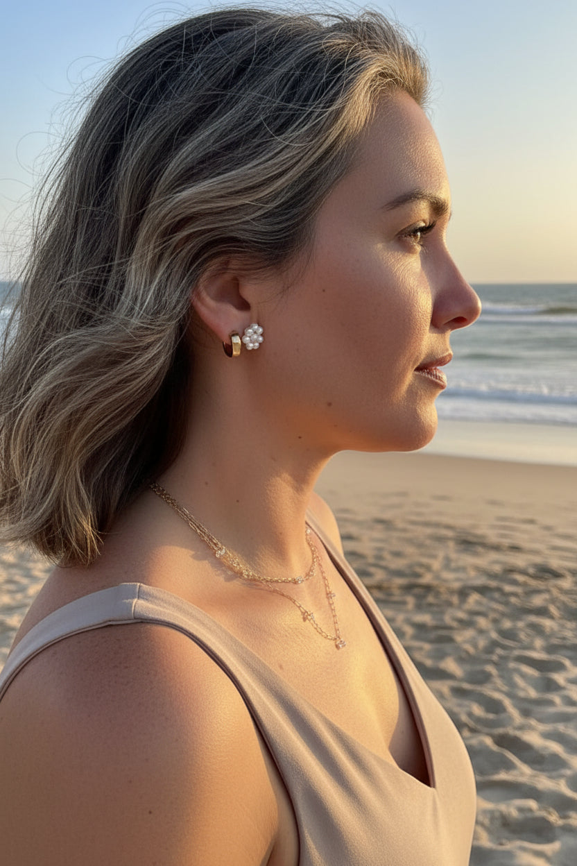 pearl daisy earring on a woman at the beach