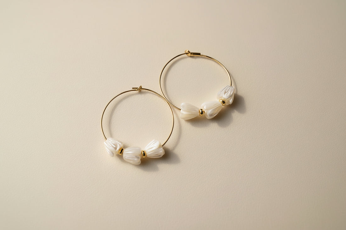 Pair of hoop earrings with floral designs on a cream background