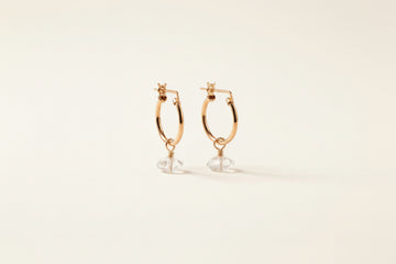 herkimer diamond on dainty gold hoop earrings with neutral background 